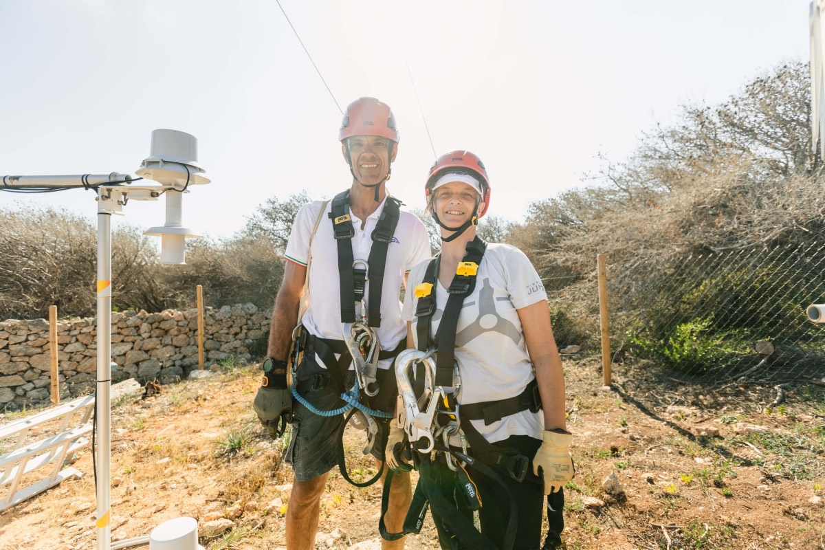 Two ICOS station staff in climbing harnesses next to a measurement mast